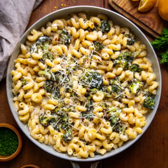 Skillet of Creamy Ricotta Pasta with Roasted Broccoli on a wooden table from overhead.