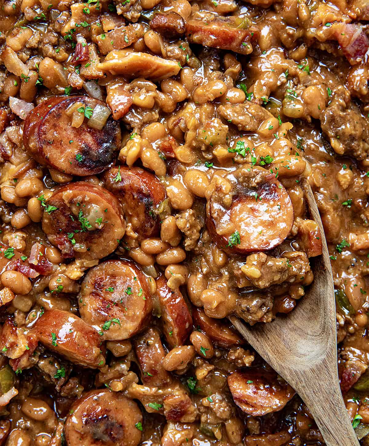 Close up of Kielbasa Cowboy Beans with a spoon.