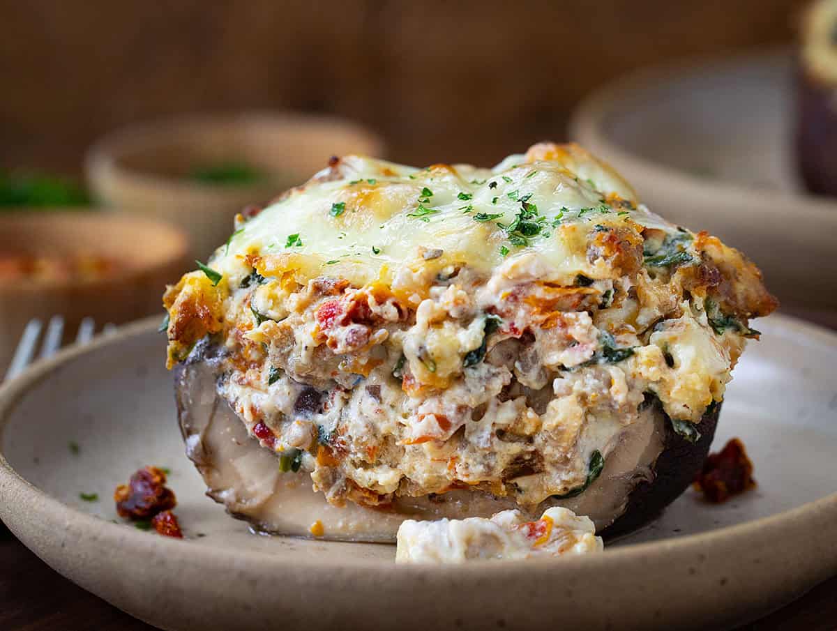 Cut in half Tuscan Stuffed Mushroom Cap on a plate.