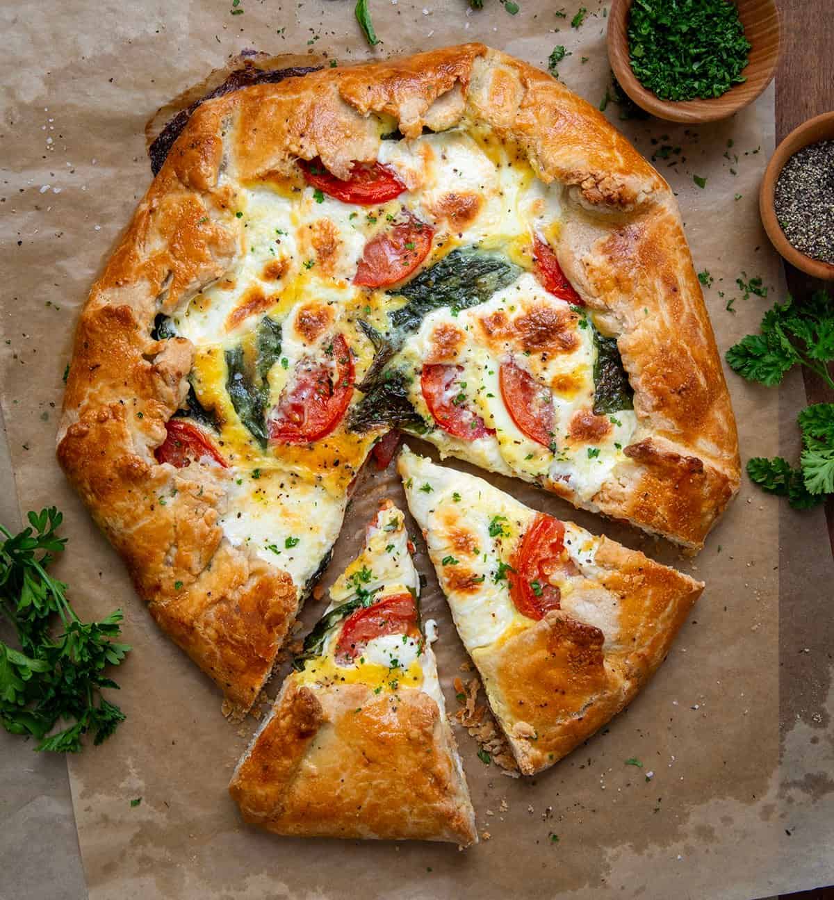 Cut into Caprese Galette from overhead.