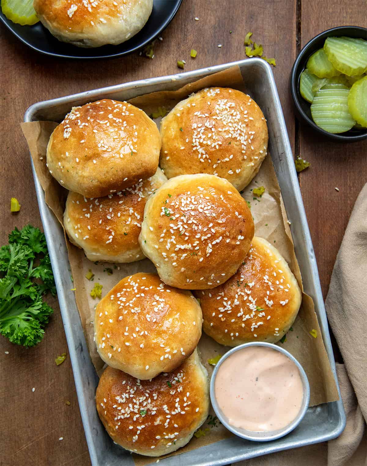 Pan of Cheeseburger Bombs on a wooden table with Fry Sauce from overhead.