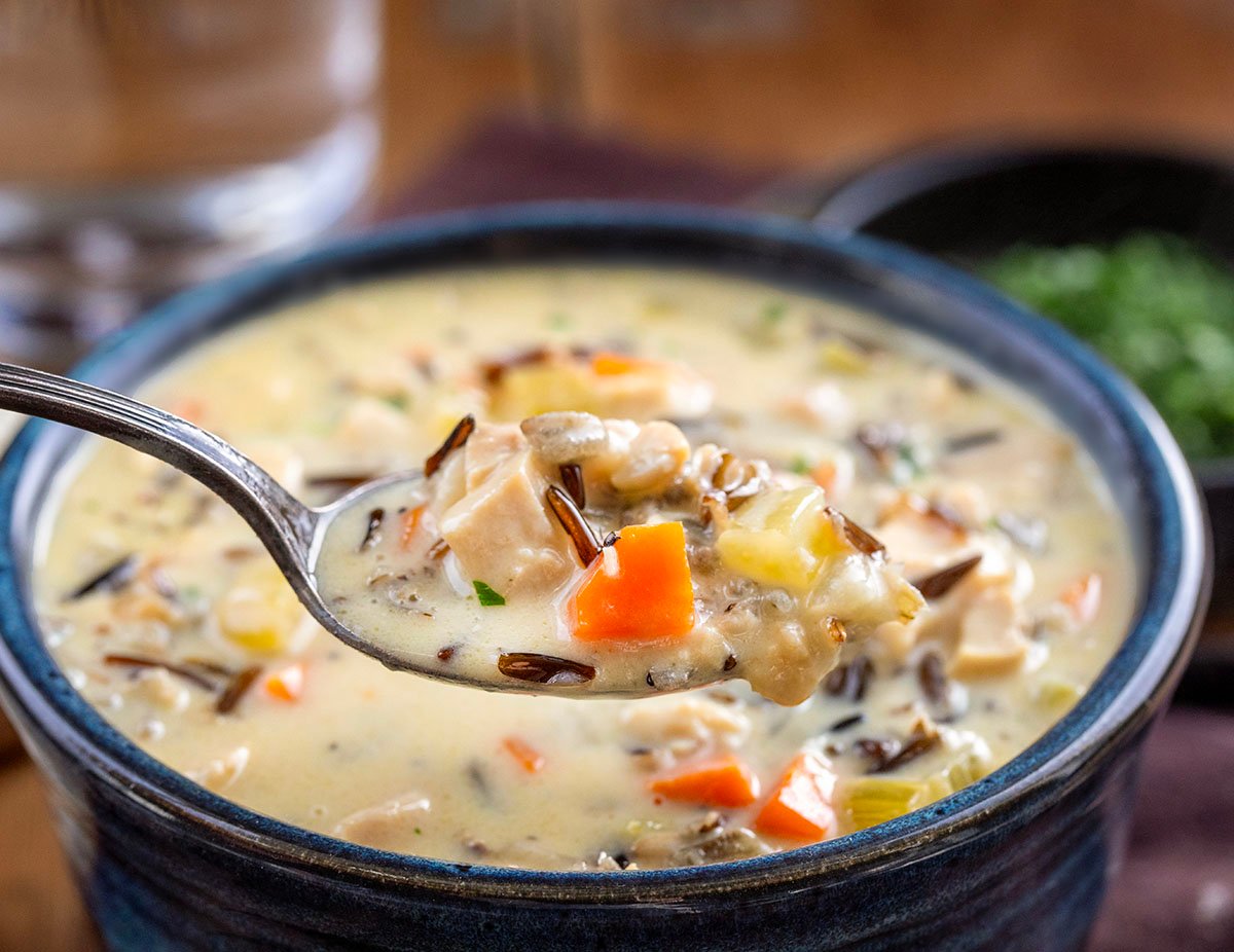 Spoonful of Chicken Wild Rice Soup in front of bowl.