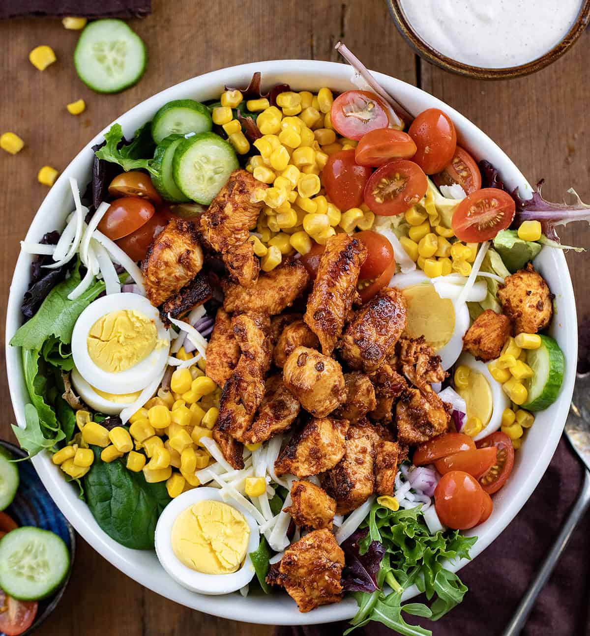 Bowl of Chipotle Chicken Cobb Salad on a wooden table from overhead. 