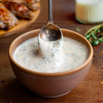 Dipping a spoon into a bowl of Cowboy Butter Ranch Dressing.