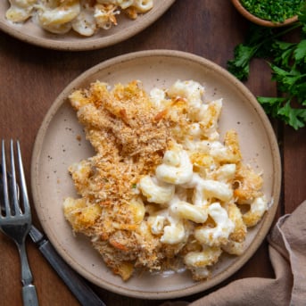 Plates of Garlic Parmesan Mac and Cheese on a wooden table from overhead.