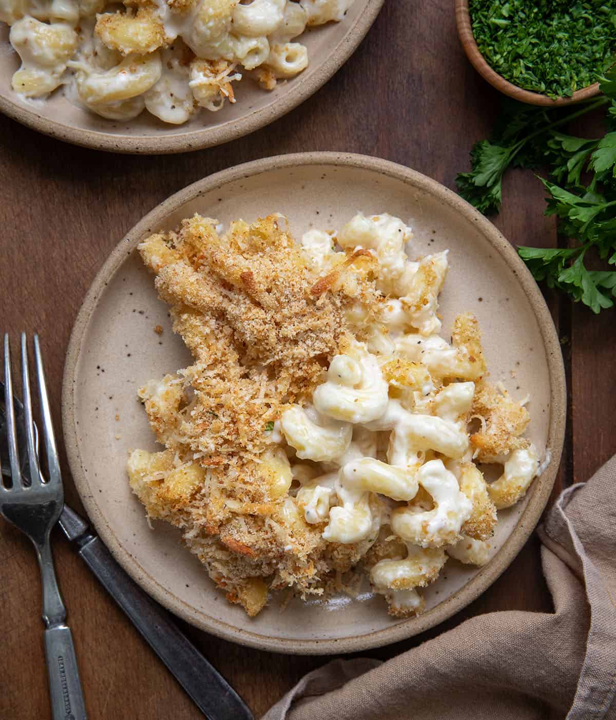 Plates of Garlic Parmesan Mac and Cheese on a wooden table from overhead.