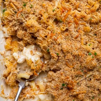 Close up of Garlic Parmesan Mac and Cheese with spoon in the pan showing the creamy noodles.