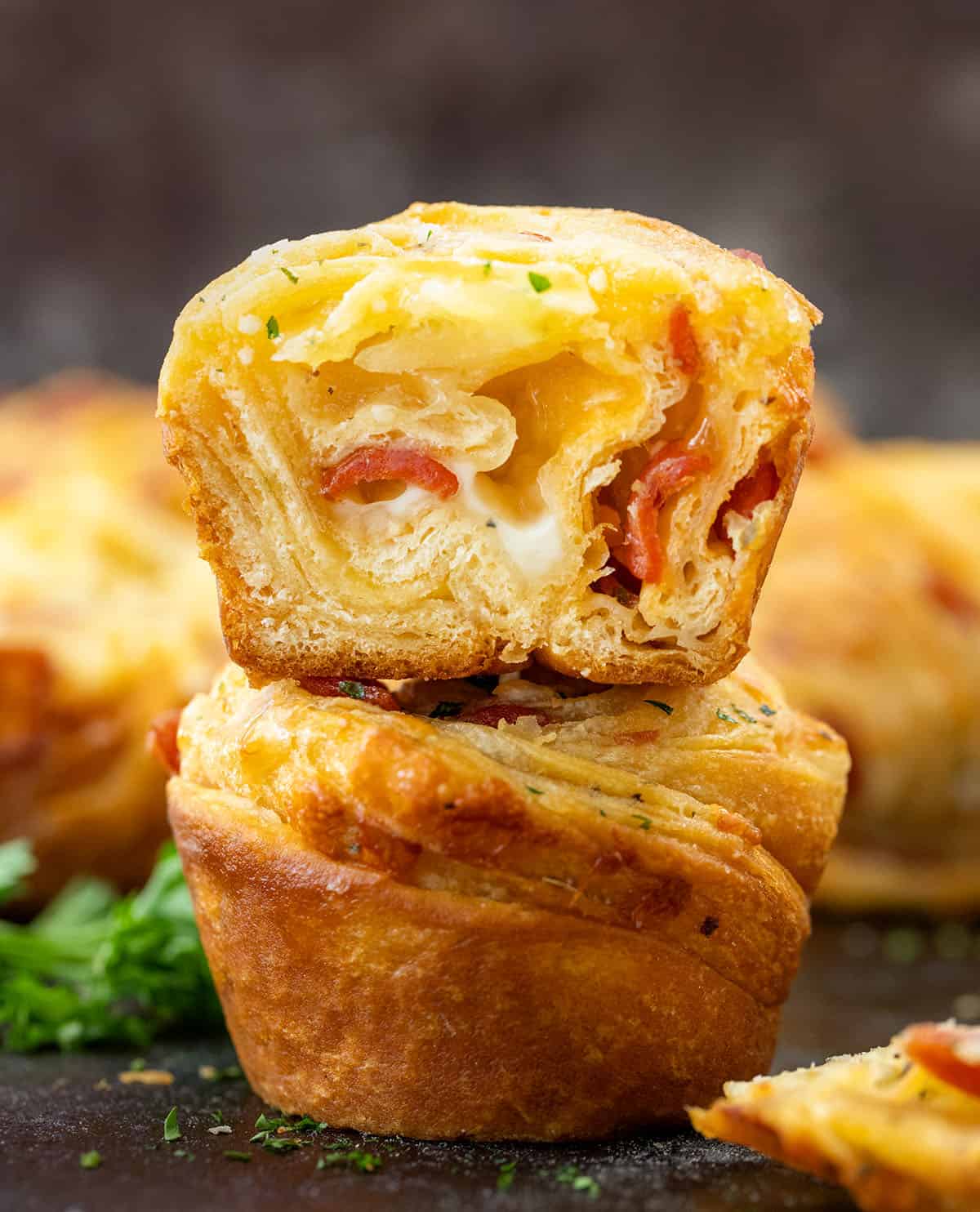 Stacked Pizza Cruffins with top cruffin cut in half showing inside texture.