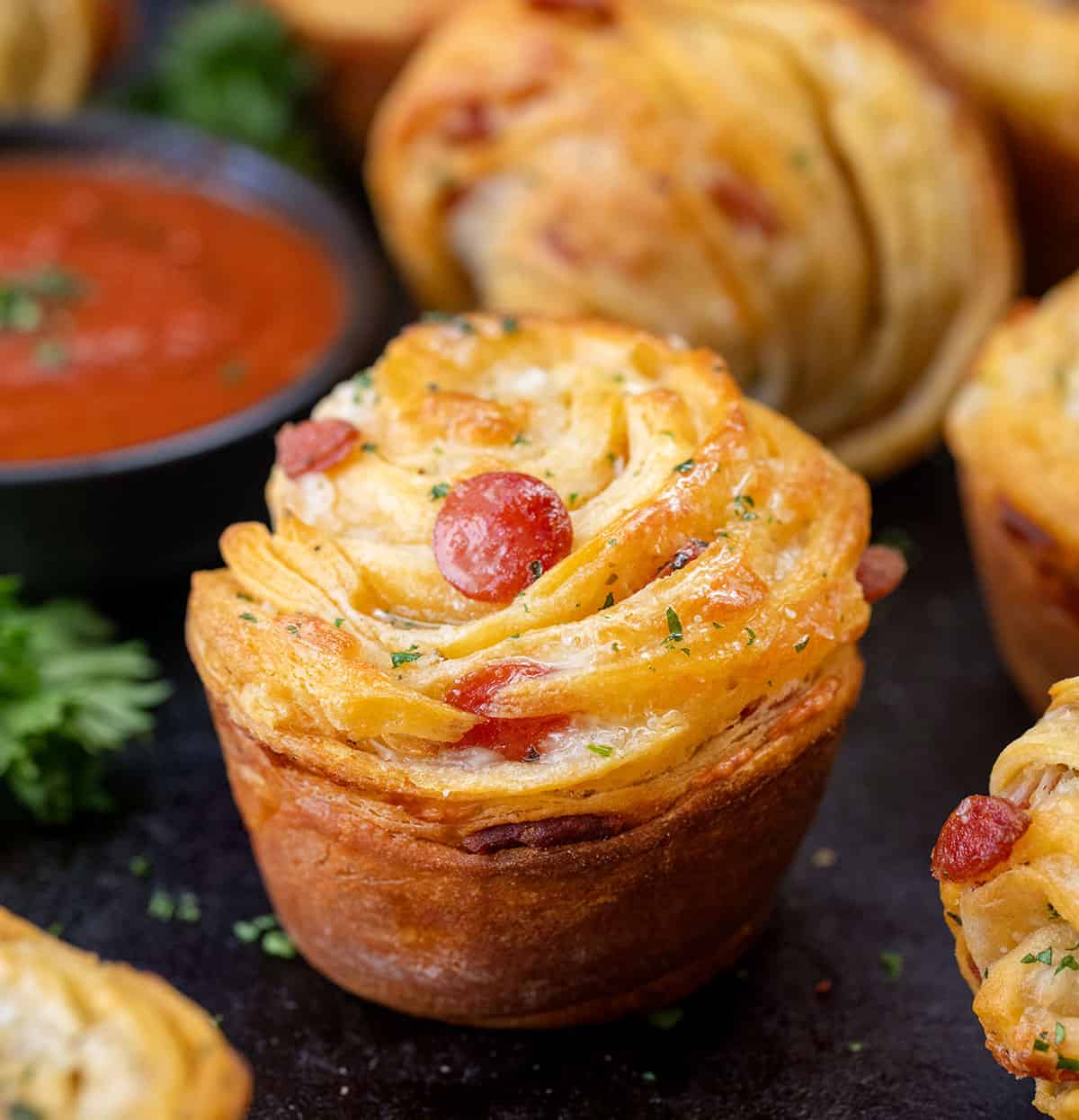 Close up of Pizza Cruffins on a dark counter.