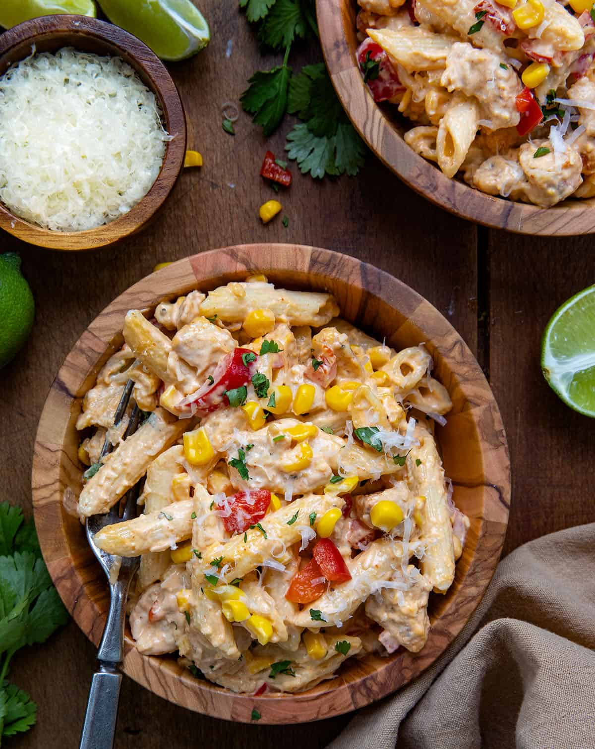 Bowls of Sriracha Chicken Pasta Salad on a wooden table from overhead.