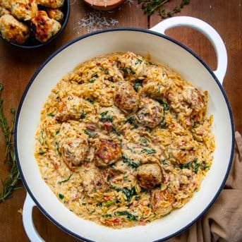 Pot of Tuscan Chicken Meatball Orzo on a wooden table from overhead.