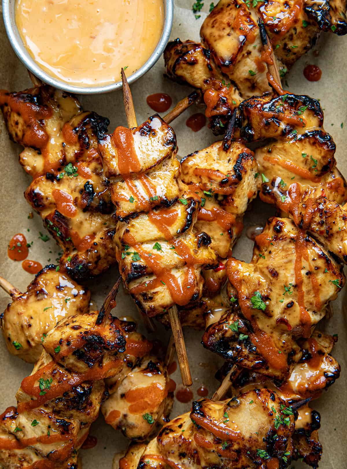 Chipotle Bang Bang Chicken Skewers in a tray with Bang Bang Sauce from overhead.