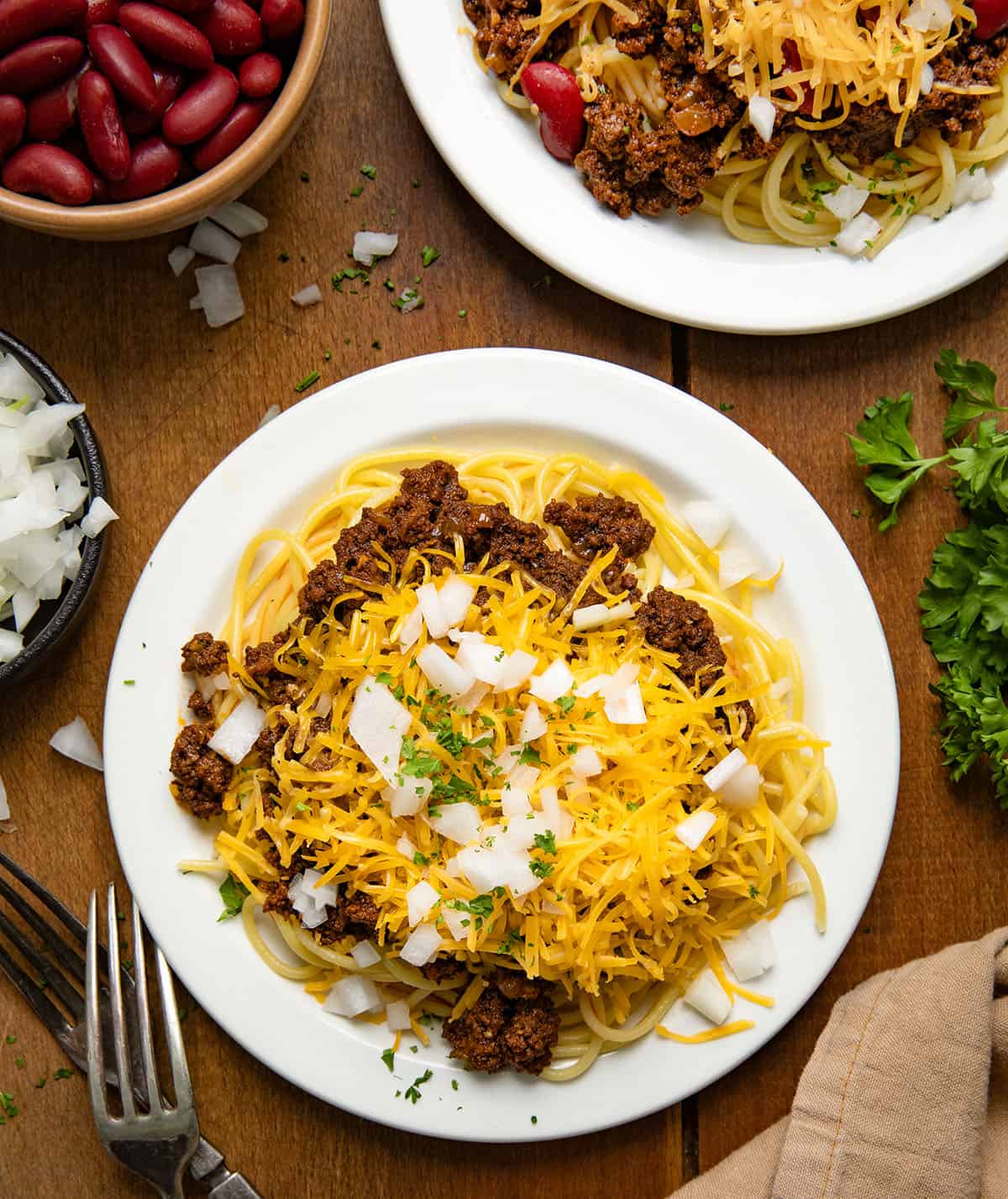 Plates of Cincinnati Chili on a wooden table from overhead.