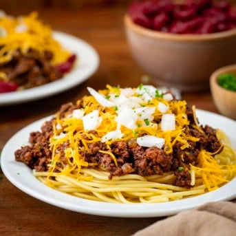 Plates of Cincinnati Chili on a wooden table close up.