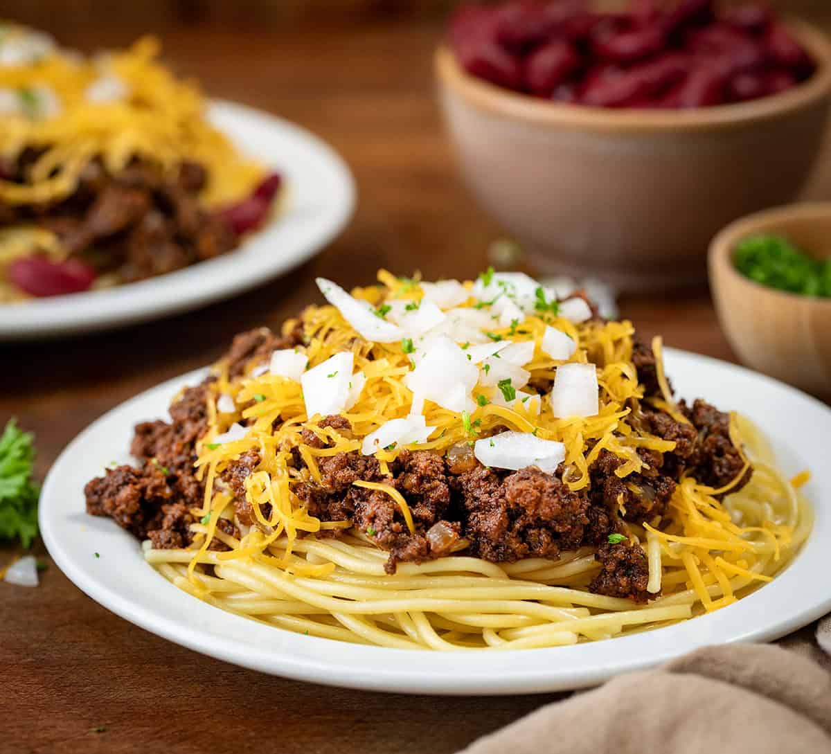 Plates of Cincinnati Chili on a wooden table close up.