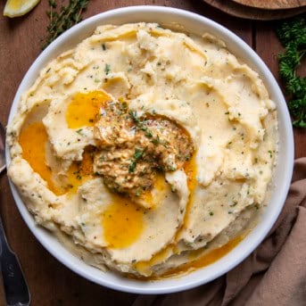 Bowl of Cowboy Butter Mashed Potatoes on a wooden table from overhead.