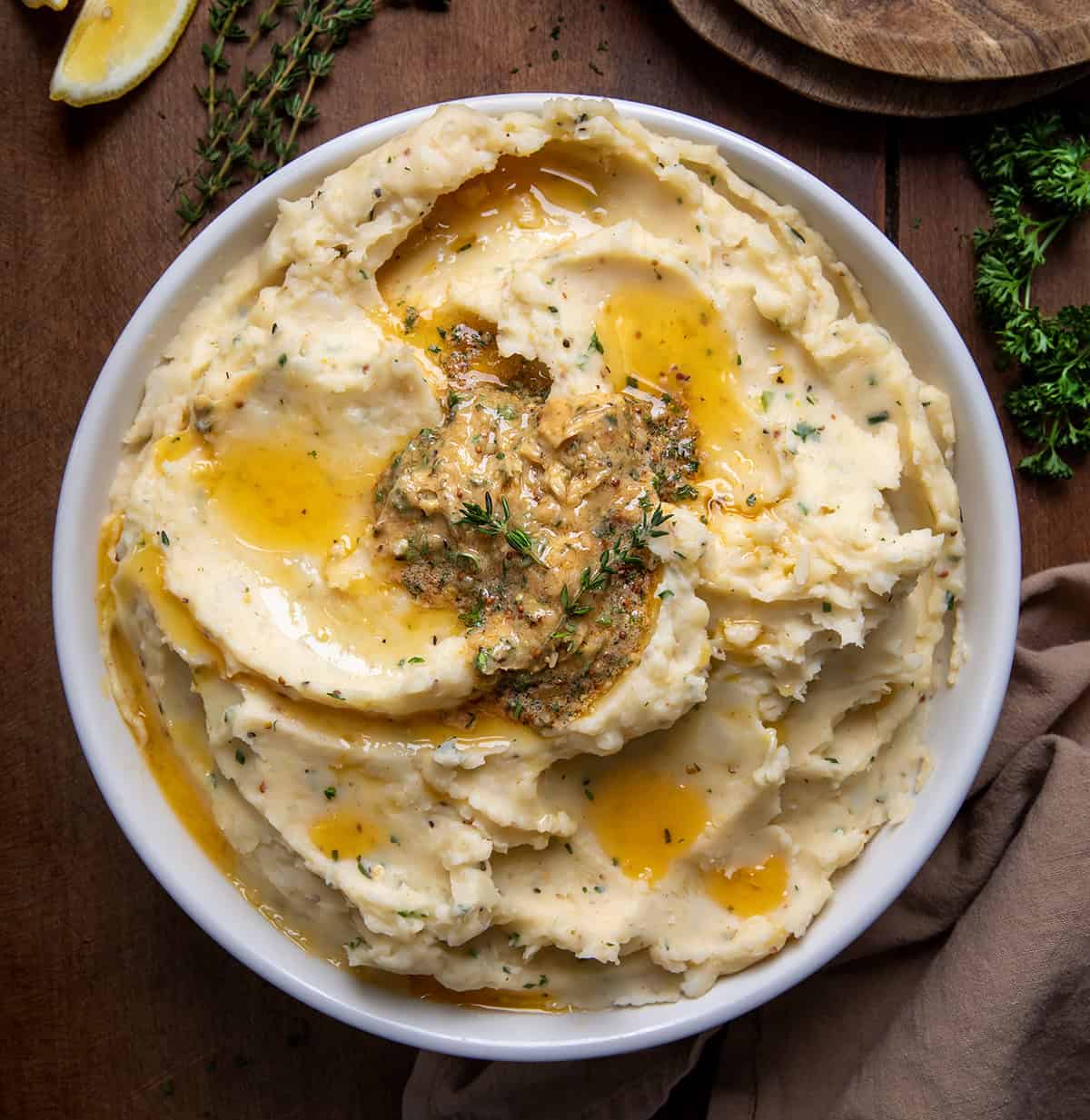 Bowl of Cowboy Butter Mashed Potatoes on a wooden table from overhead.