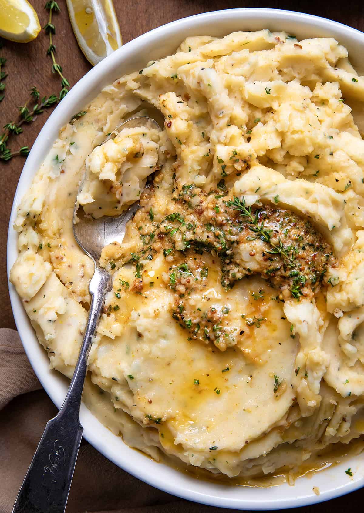 Close up of a bowl of Cowboy Butter Mashed Potatoes with a spoon in them.