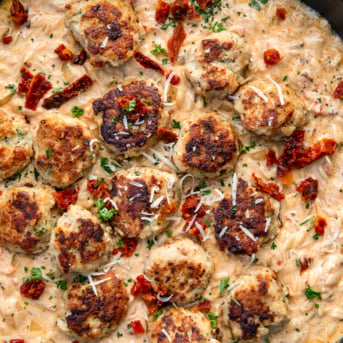 CLose up of Marry Me Chicken Meatball Orzo in a skillet from overhead.