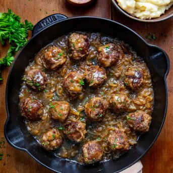 Skillet of Salisbury Steak Meatballs on a wooden table from overhead.