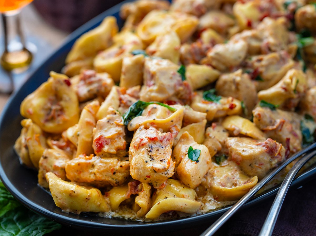 Close up of a serving platter of Tuscan Chicken Tortellini from the side.