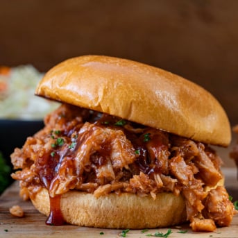 Two Ingredient Pulled Pork Sandwich on a wooden table.