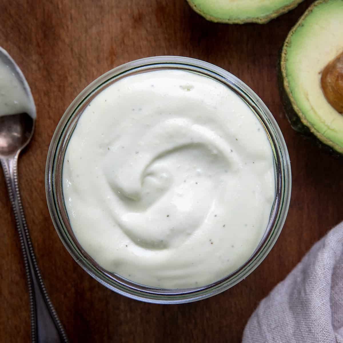 Looking down on a jar of Avocado Ranch Dressing on a wooden table.