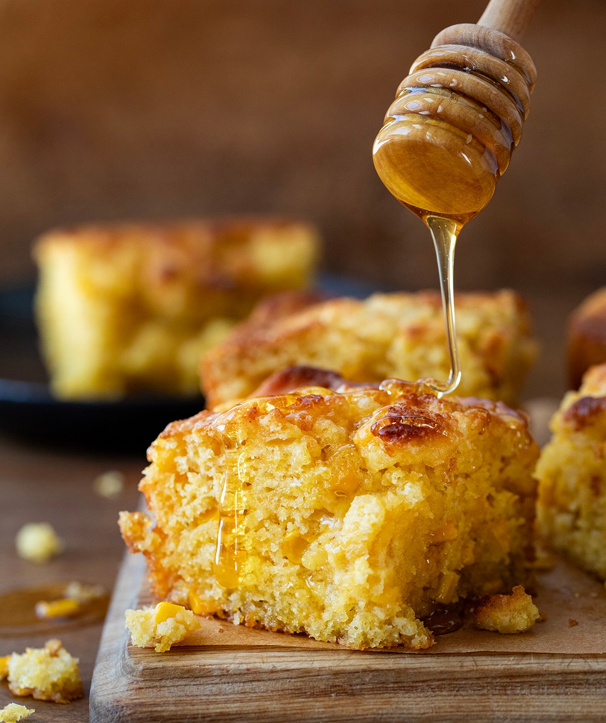 Drizzling honey over Cornbread Butter Swim Biscuits.