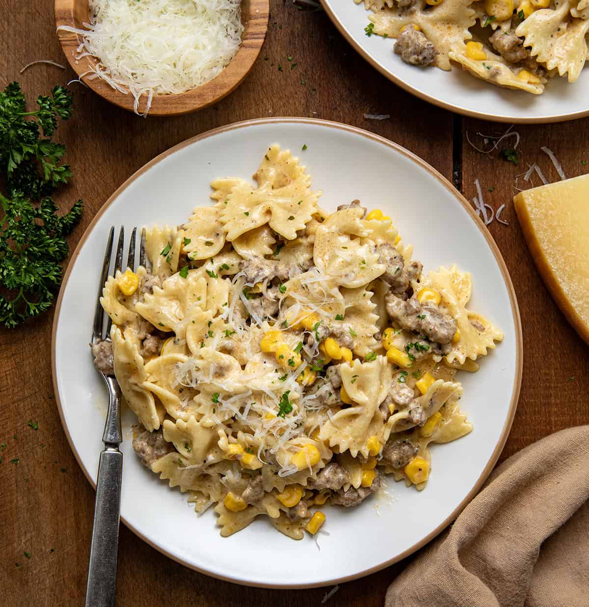 White plates with Creamy Ranch Beef Pasta on them on a wooden table from overhead.