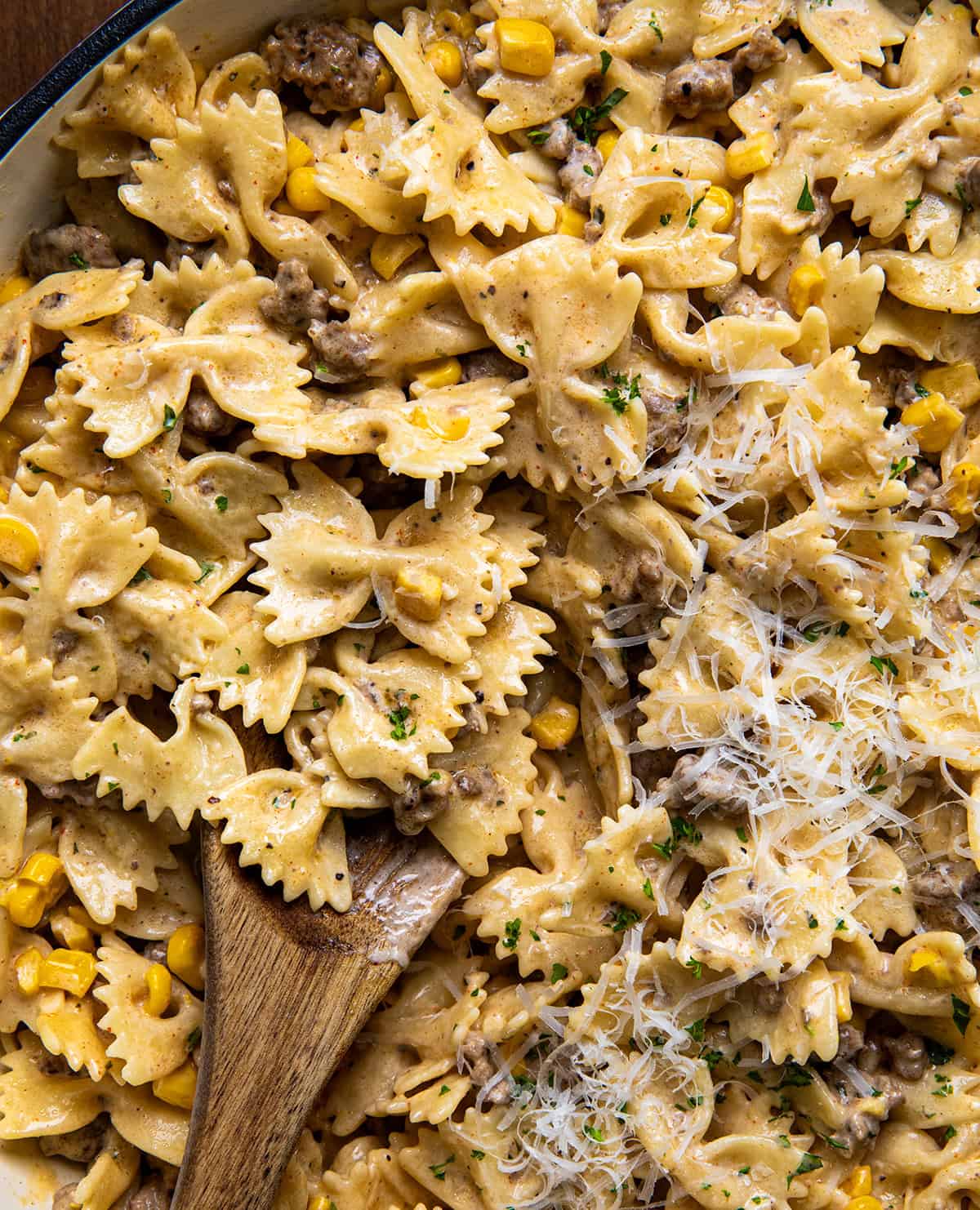 Close up of Creamy Ranch Beef Pasta in a skillet with a wooden spoon.