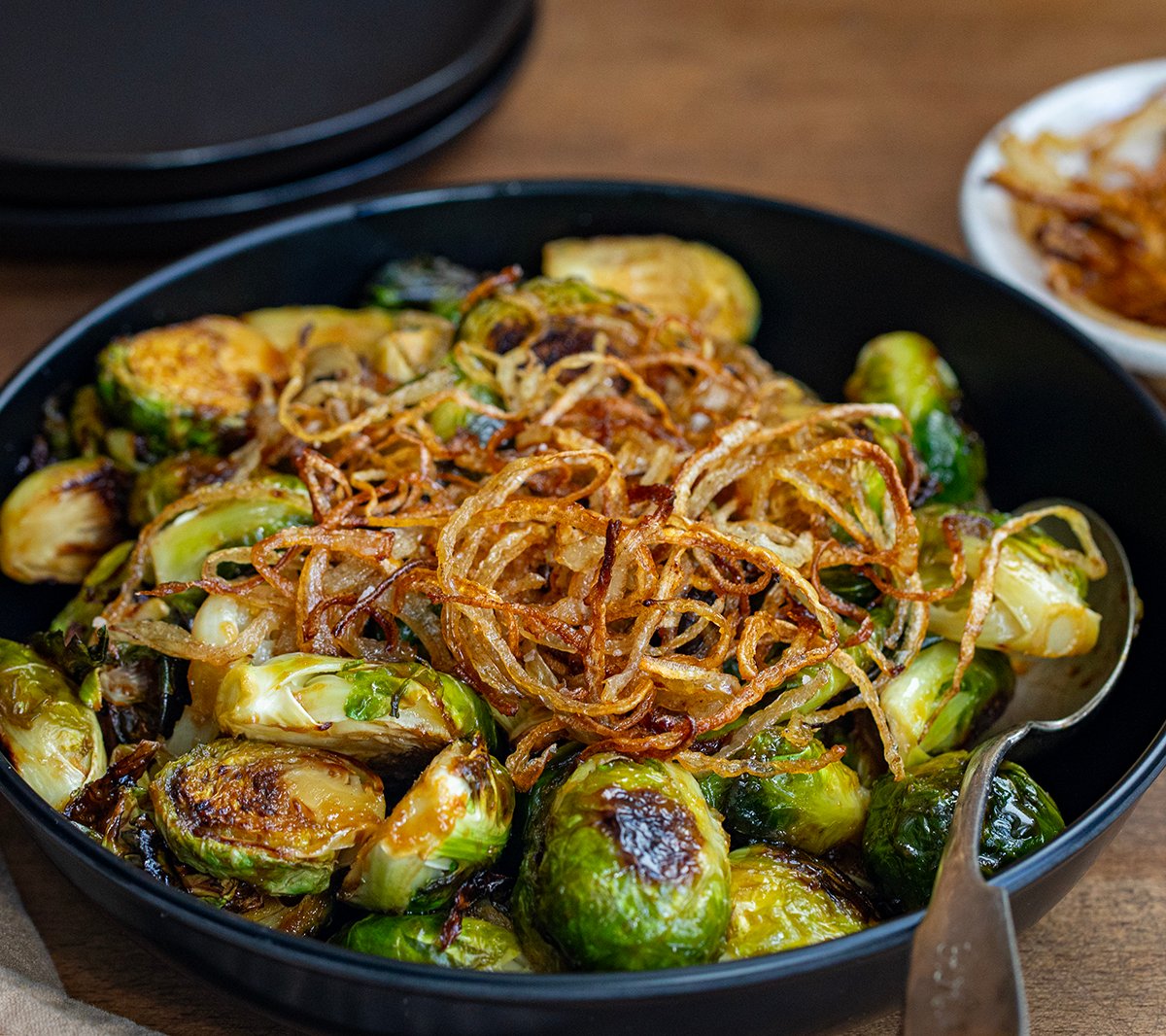 Red Lobster Crispy Brussels Sprouts on a black plate on wooden table.