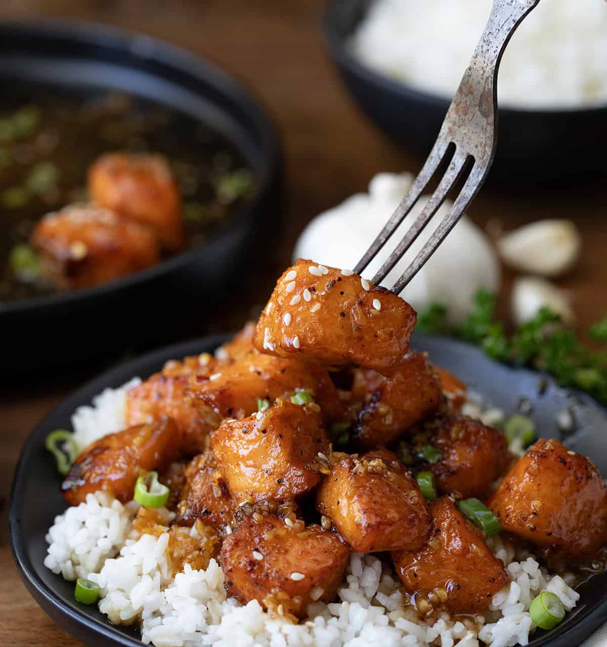 Fork picking up a Honey Garlic Salmon Bite from plate.