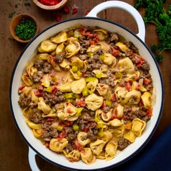 One Pot Cheeseburger Tortellini in a pot on a wooden table from overhead.