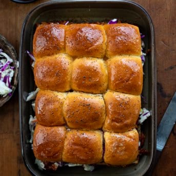 Pan of Pulled Pork Sliders on a wooden table from overhead.