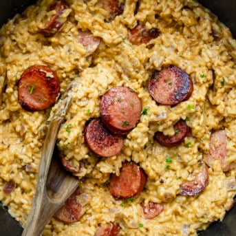 Close up of Cajun Sausage and Rice in a pot with a wooden spoon from overhead.