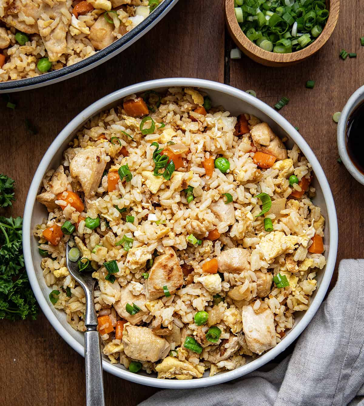 Bowls of Chicken Fried Rice on a wooden table from overhead.