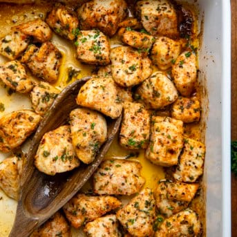 Casserole pan full of Cowboy Chicken Bites with a spoon in the pan shot from overhead.