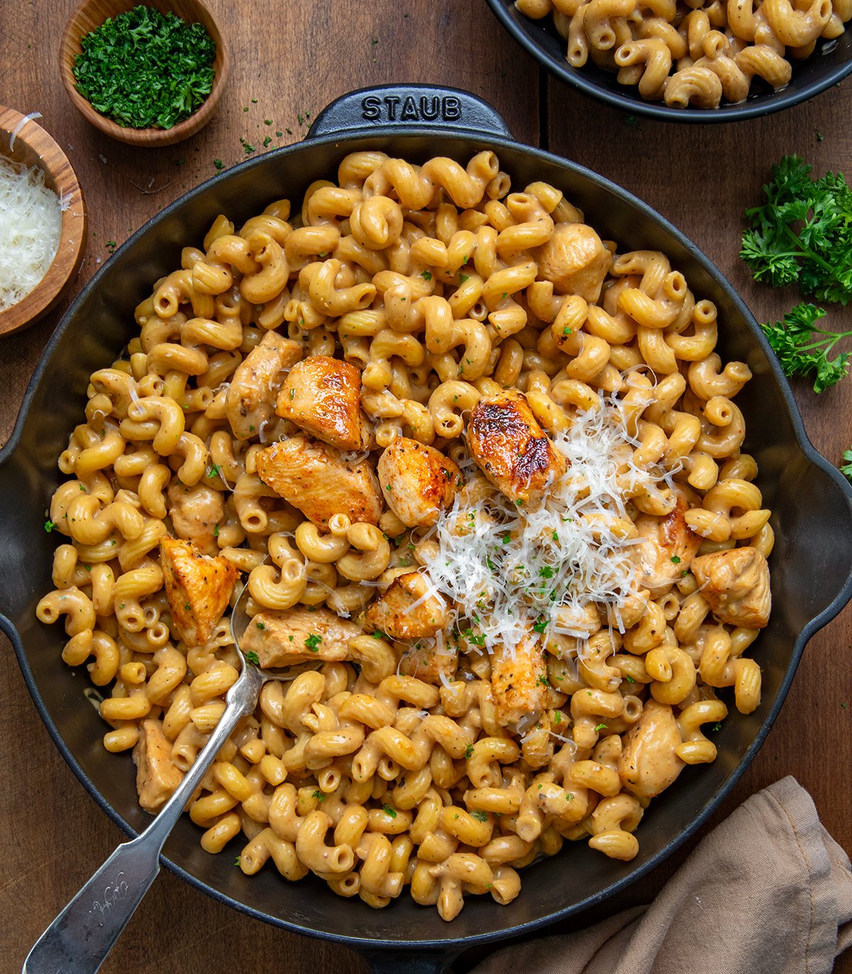 Skillet of Creamy Garlic Parmesan Chicken Pasta on a wooden table from overhead.