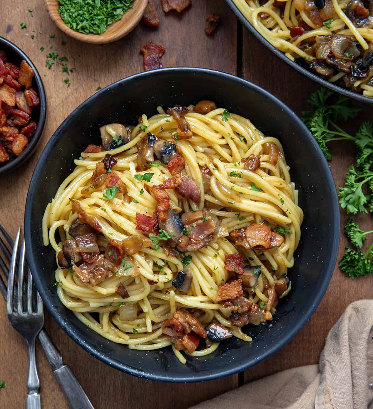 Bowls of Mushroom and Onion Carbonara on a wooden table from overhead.