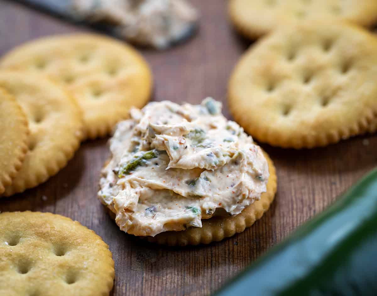 Ritz cracker with Roasted Jalapeño Cowboy Cream Cheese on it on a wooden table.