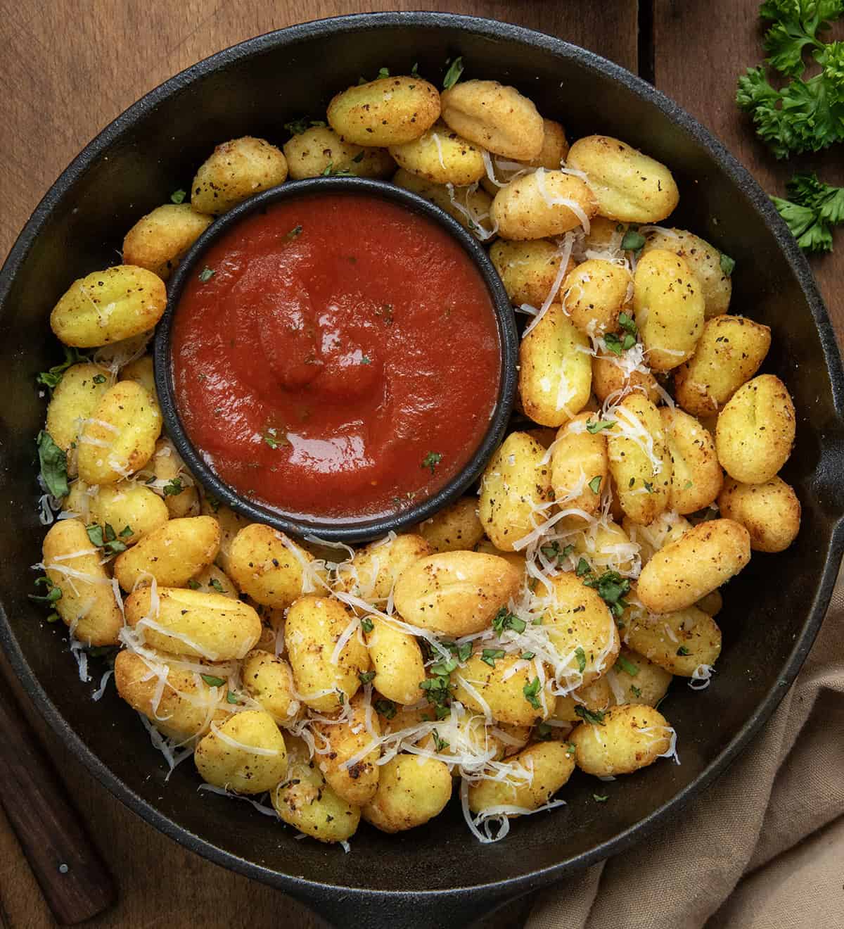 Skillet of Gnocchi Bites with a ramekin of marinara sauce.