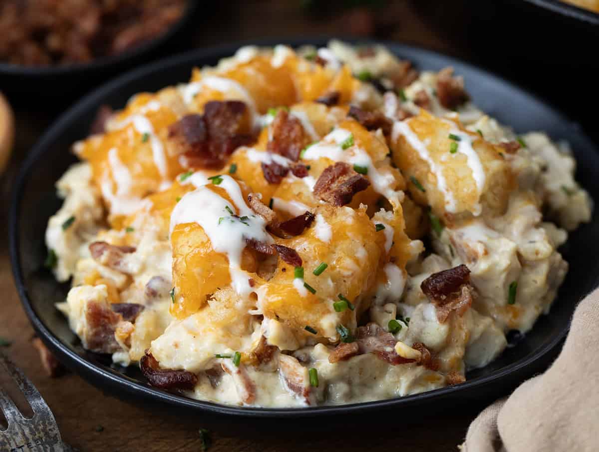 Black plate with Chicken Bacon Ranch Tater Tot Casserole on it close up.