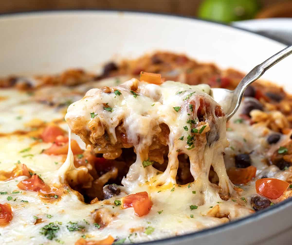 Spoon lifting up a portion of Cheesy Chicken Taco Rice.