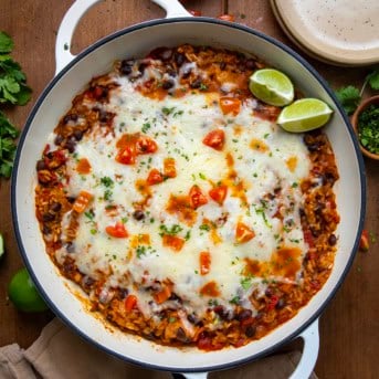 Skillet of Cheesy Chicken Taco Rice on a wooden table from overhead.