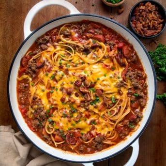 Skillet of One Pot Cowboy Spaghetti on a wooden table from overhead.
