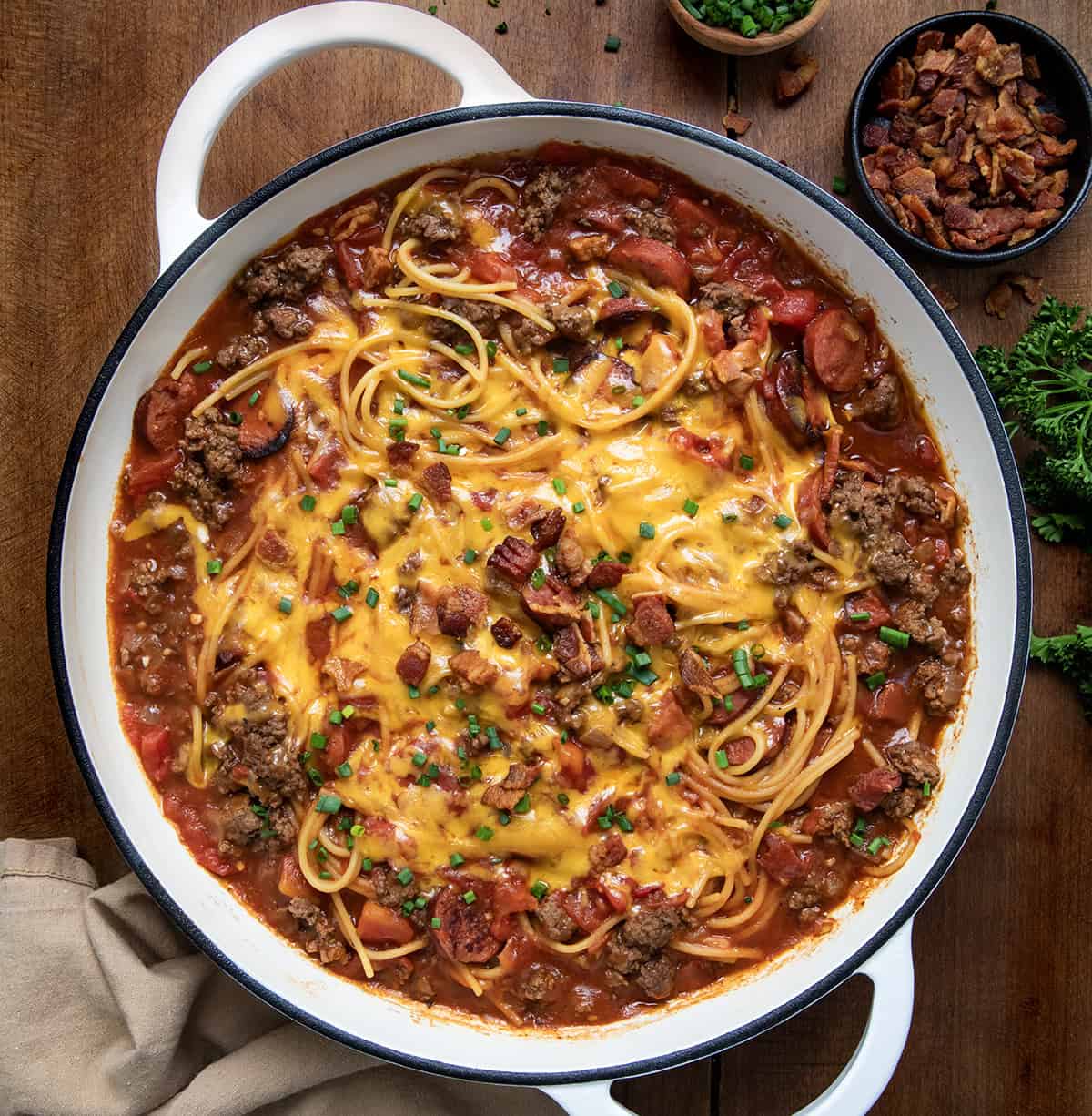 Skillet of One Pot Cowboy Spaghetti on a wooden table from overhead.