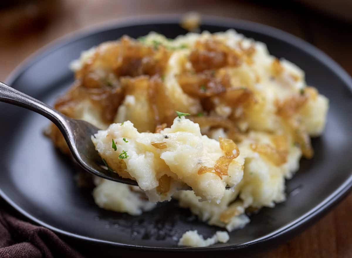 Fork picking up a creamy bite of Twice Baked French Onion Mashed Potatoes.