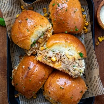 Carnitas Street Corn Sliders in a small black platter on a wooden table from overhead.
