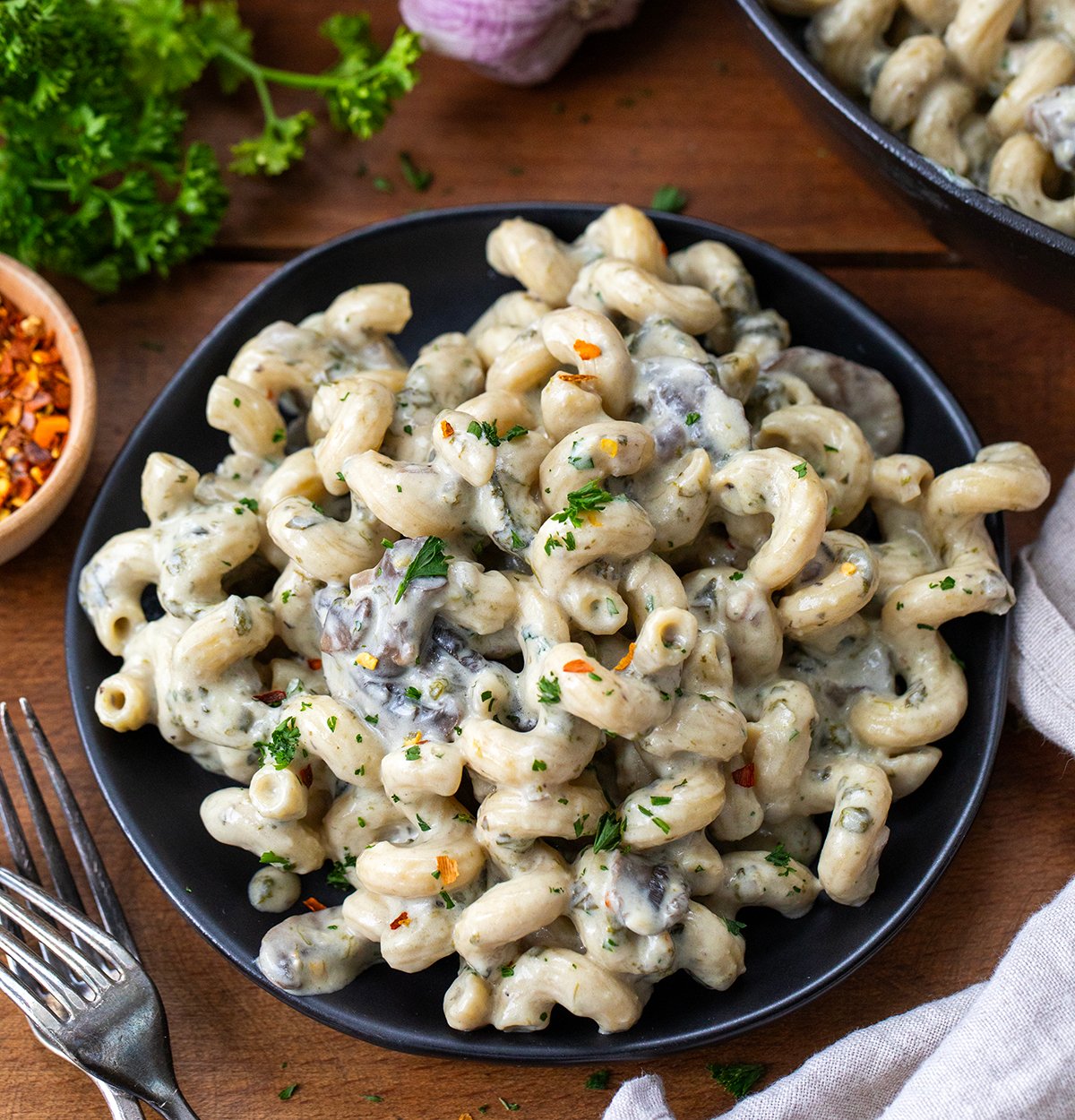 Roasted Garlic Mushroom Pasta on a black plate close up.