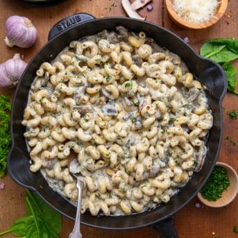 Roasted Garlic Mushroom Pasta in a skillet on a wooden table from overhead.